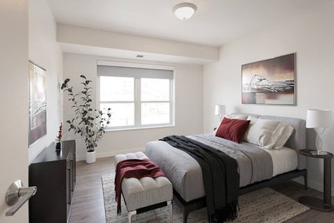 A bedroom with a large bed and a painting on the wall.