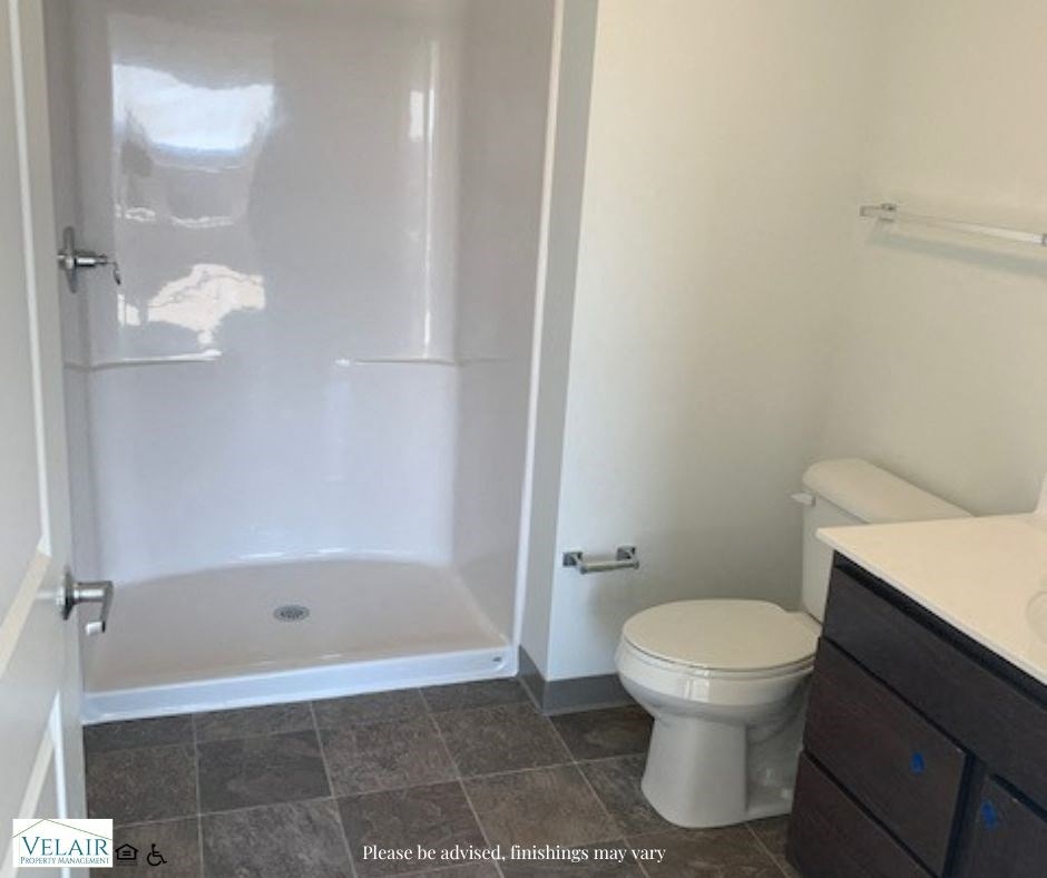 A bathroom with a toilet, sink, and shower.