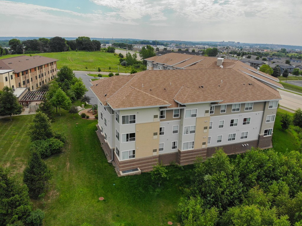A large apartment complex with a green lawn in front.