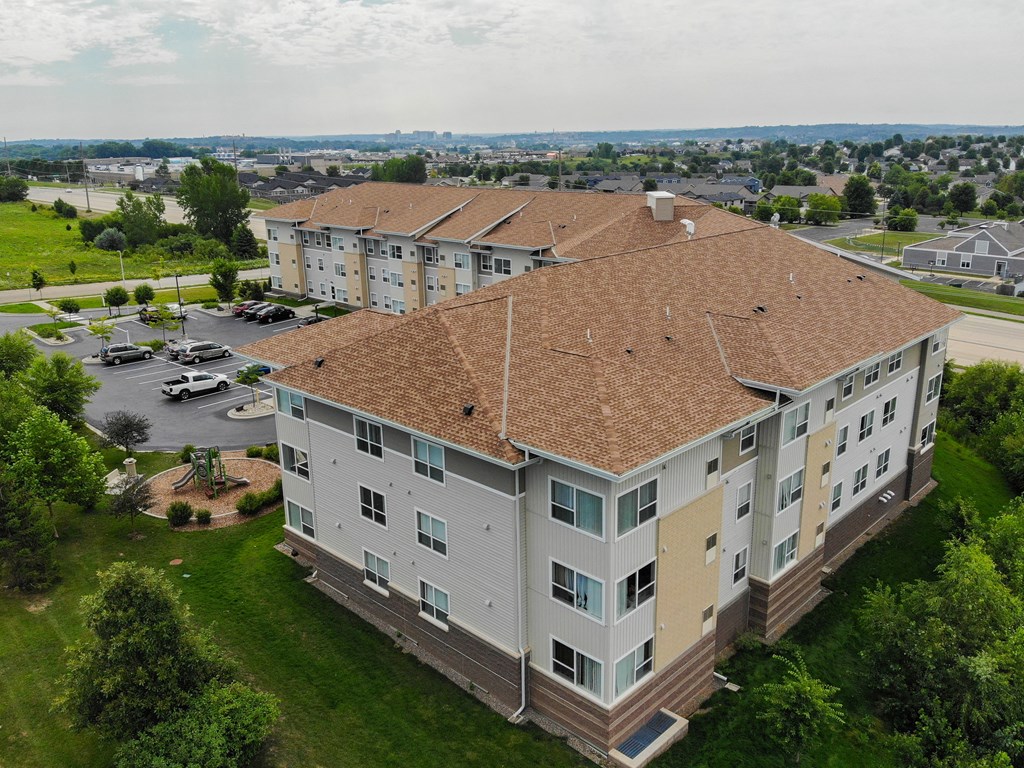 A large apartment complex with a parking lot in front.