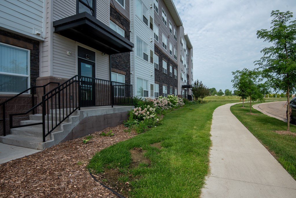 an apartment building with a sidewalk in front of it