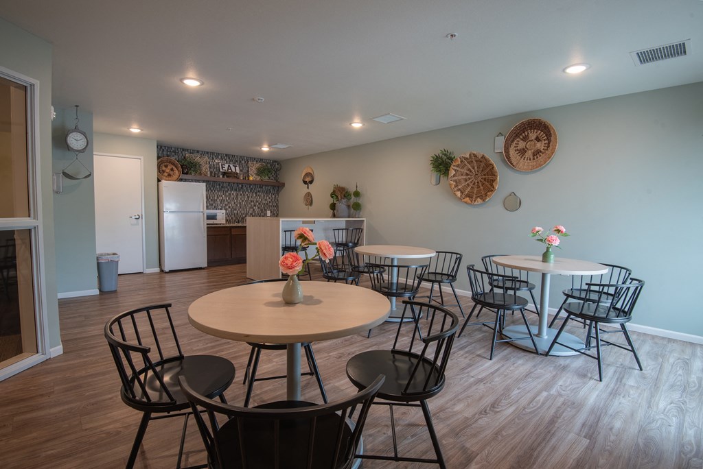 a dining room with tables and chairs and a kitchen