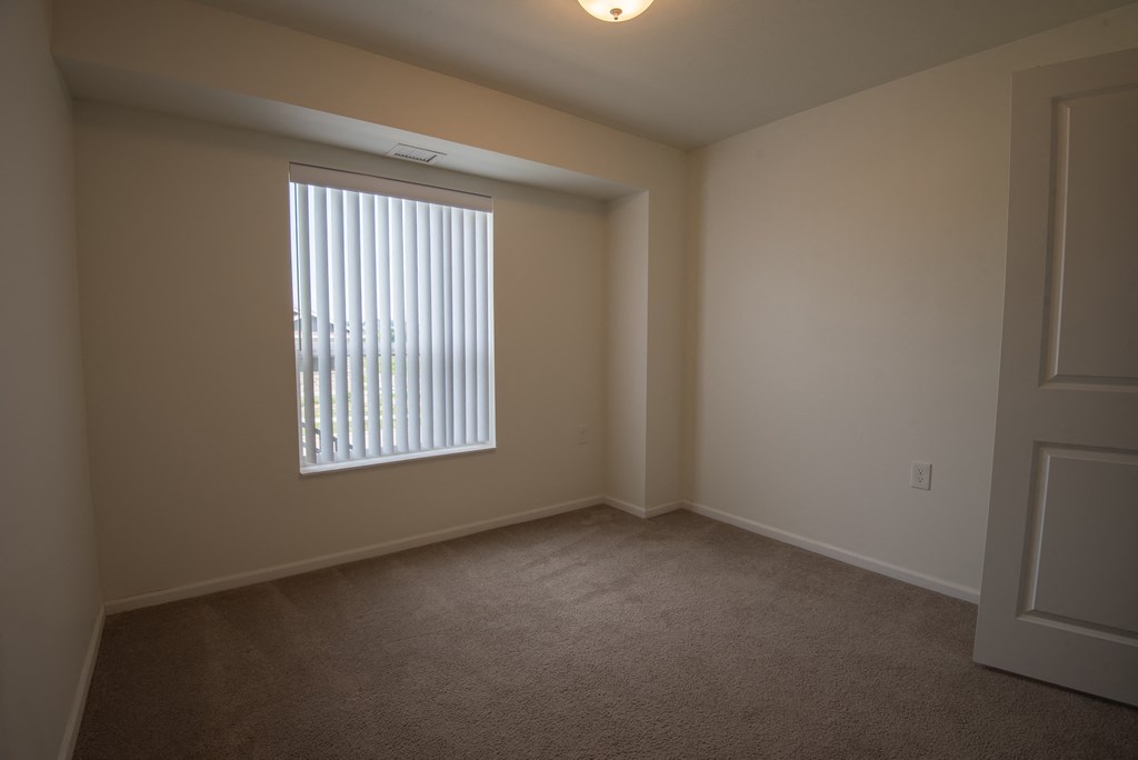 an empty room with a window and a door