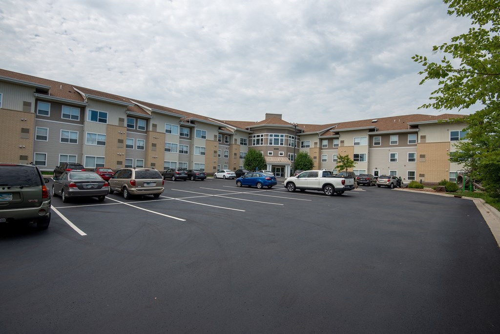 A parking lot with cars and apartment buildings in the background.