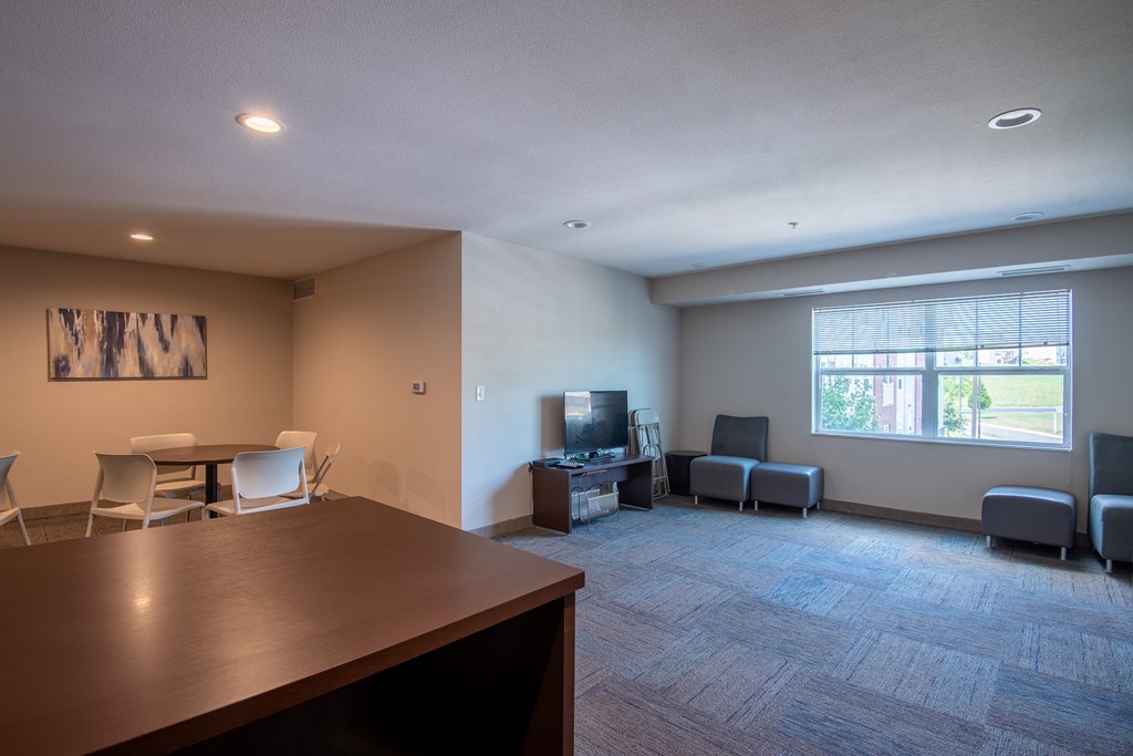 an empty living room with a table and chairs