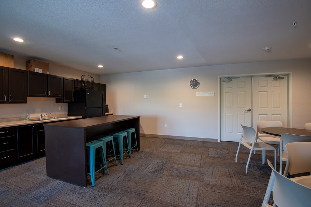 a kitchen and dining room with a bar and chairs and a table