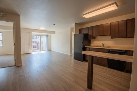 A kitchen with wooden cabinets and a black refrigerator.