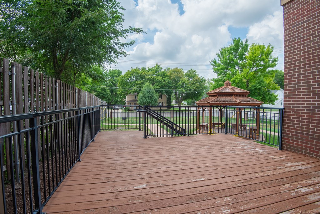 a deck with a gazebo on the side of a building