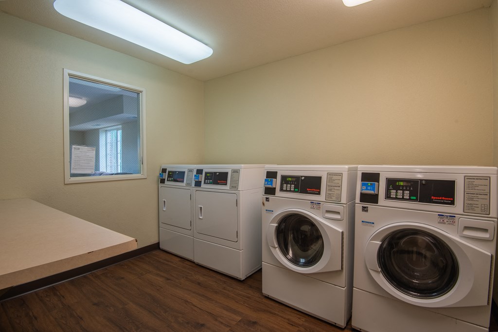 a laundry room with washers and dryers and a window