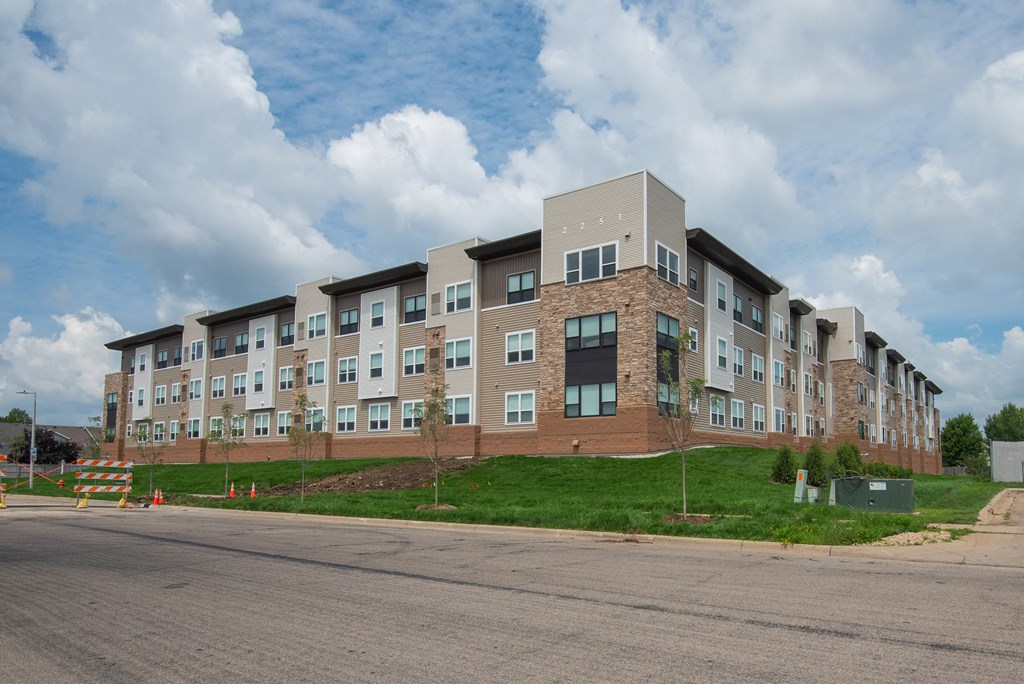 A large apartment complex with multiple buildings and a parking lot in front.