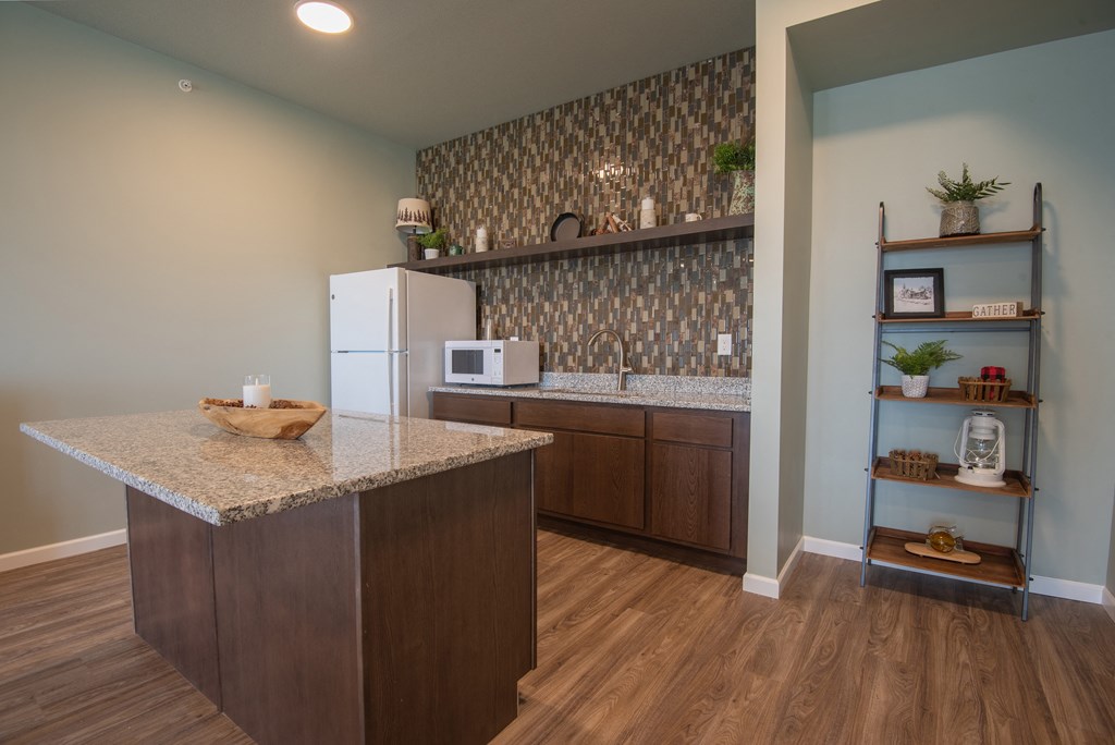 A kitchen with a granite countertop and a refrigerator.