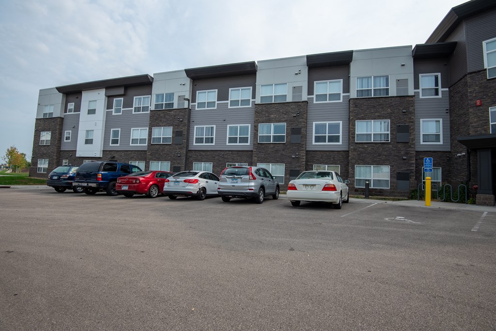 A parking lot with cars and a building in the background.