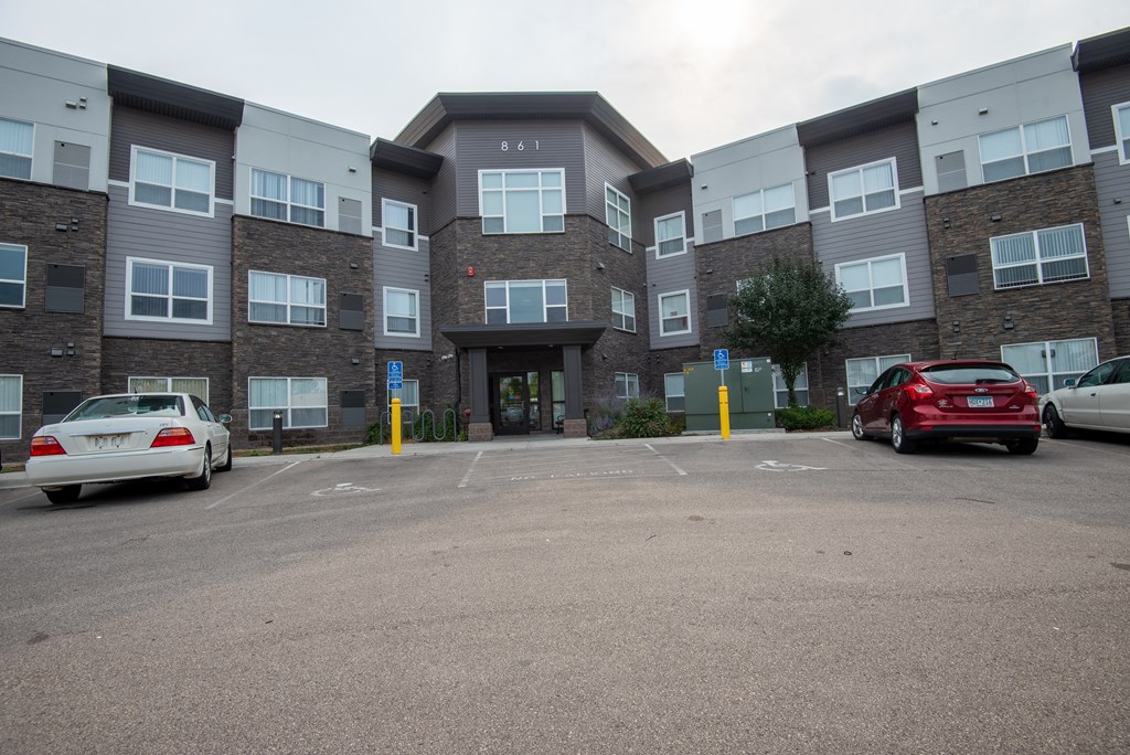 an empty parking lot in front of an apartment building