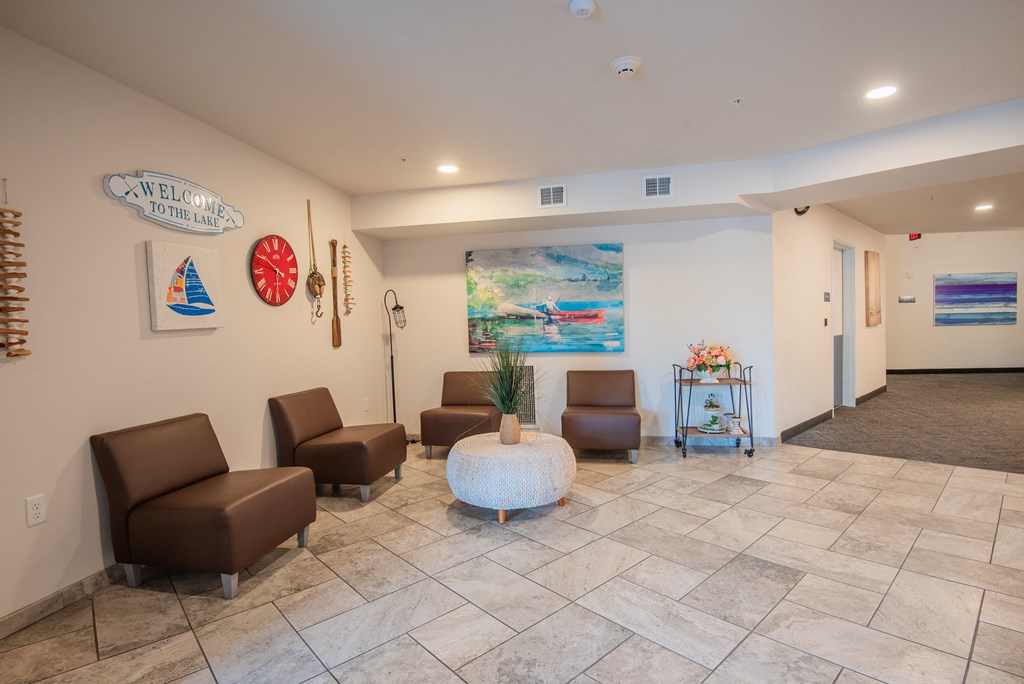 A lobby area with a white reception desk and brown leather chairs.