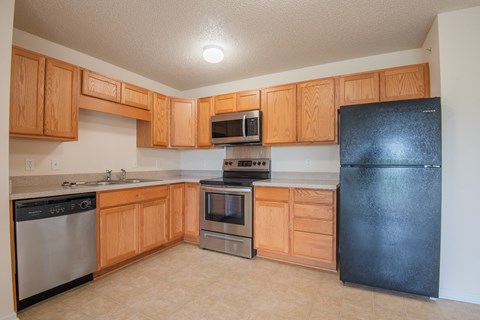 A kitchen with wooden cabinets and black appliances.