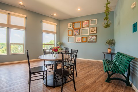 A dining room with a table set for six and a bench.