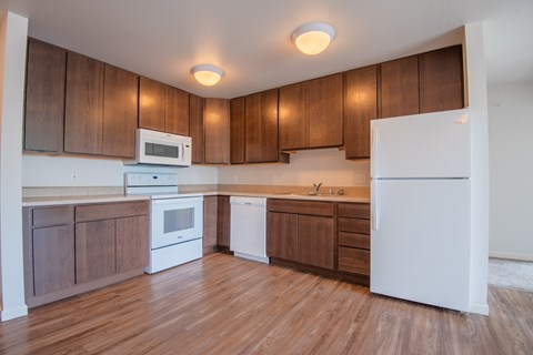 A kitchen with wooden cabinets and white appliances.