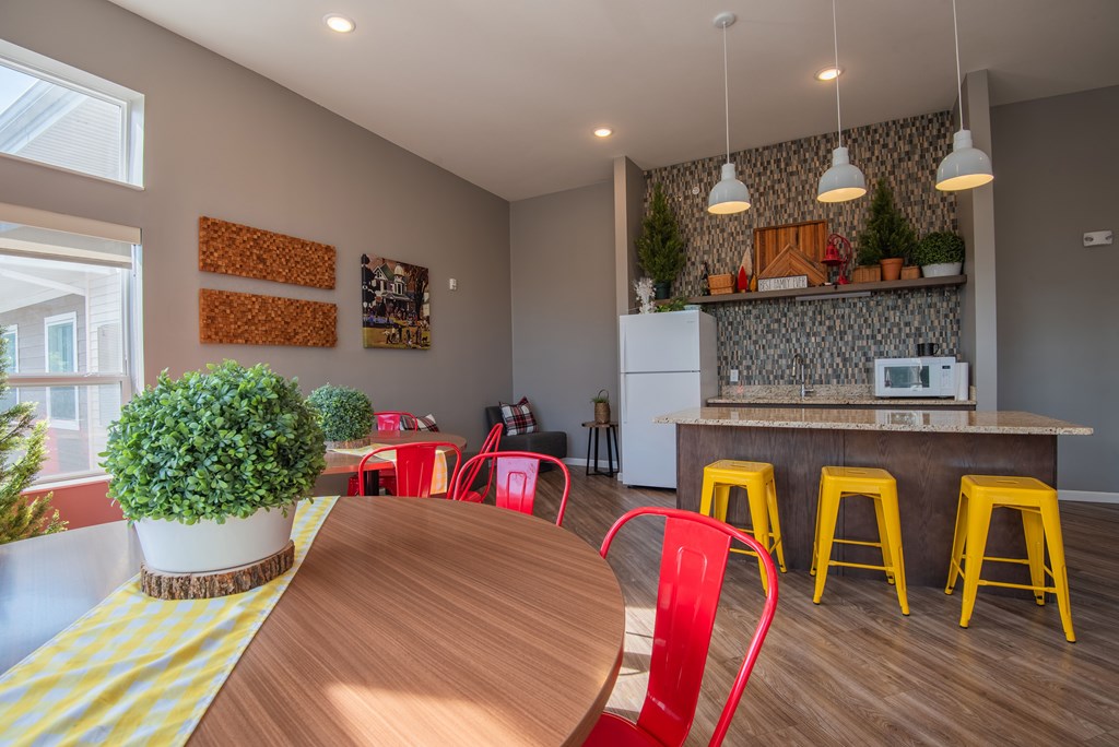 A kitchen with a wooden table and red chairs.