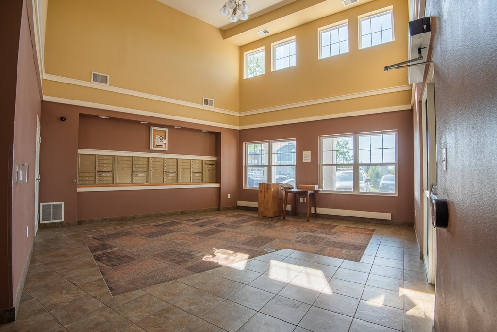 A large room with a brown floor and a brown wall with a window.