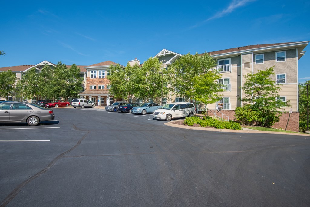 A parking lot with cars and apartment buildings in the background.