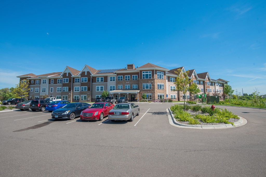 A parking lot with cars and a building in the background.