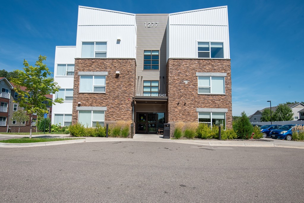 A modern building with a glass entrance and a brick wall.