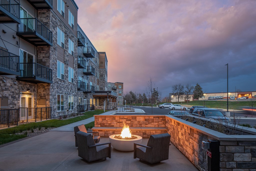 an outdoor patio with a fire pit at dusk
