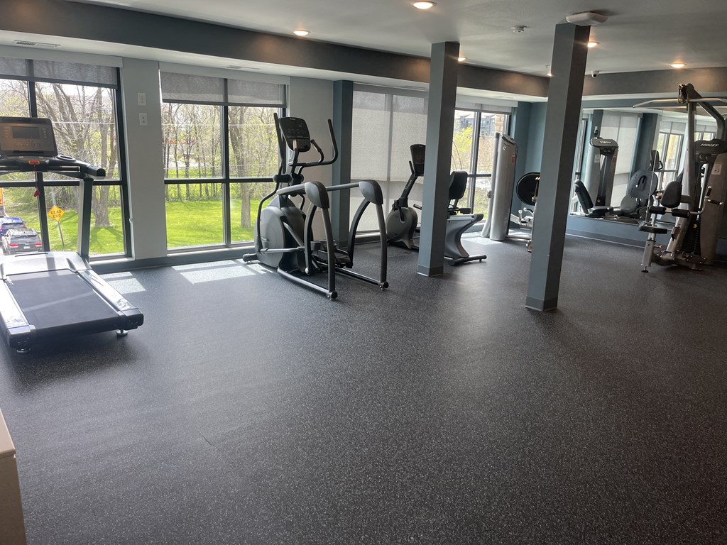 a gym with exercise equipment and windows in a building