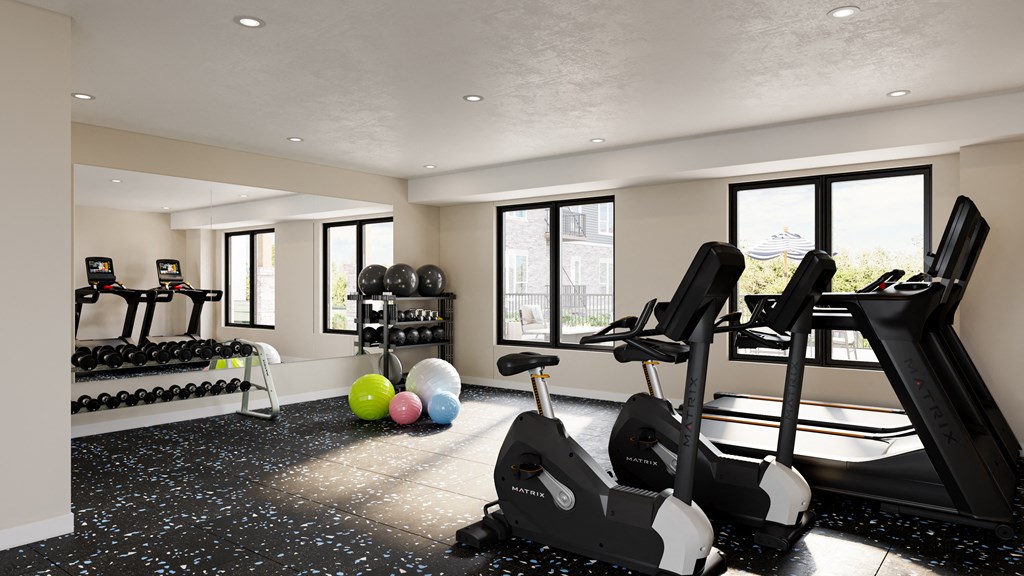 a gym with weights and balls in the corner of a room