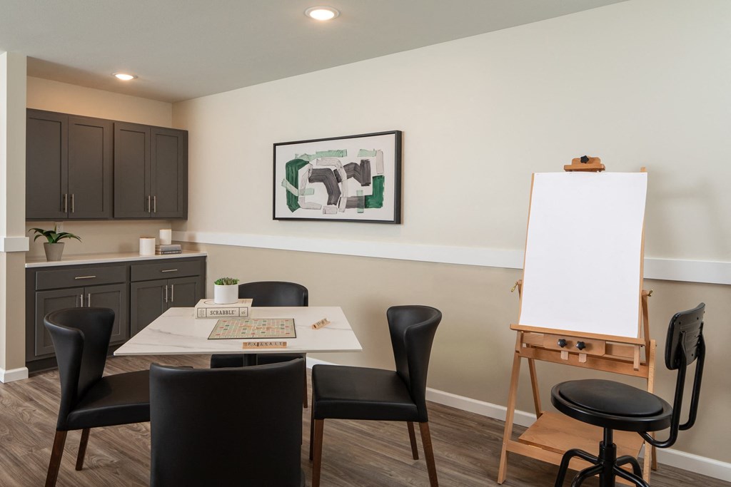 a dining room with a table and chairs and a white board on a easel
