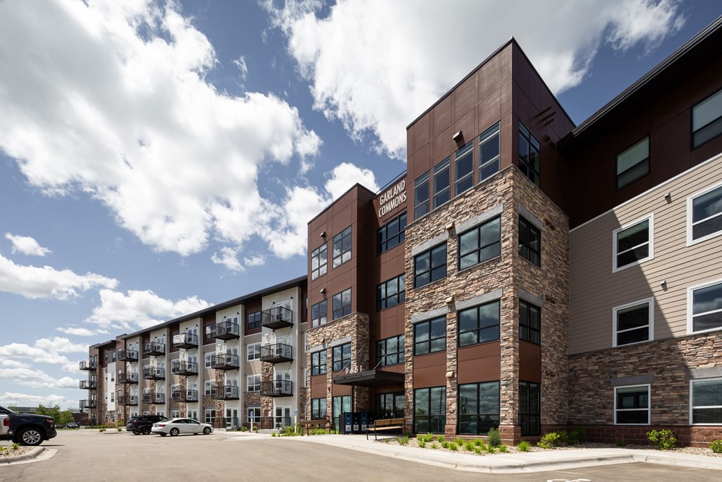 an exterior view of a building with cars parked in front of it