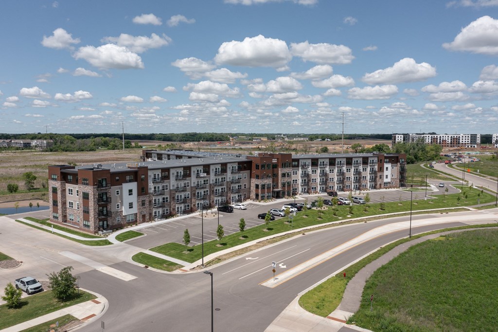 an aerial view of an empty parking lot with apartment buildings