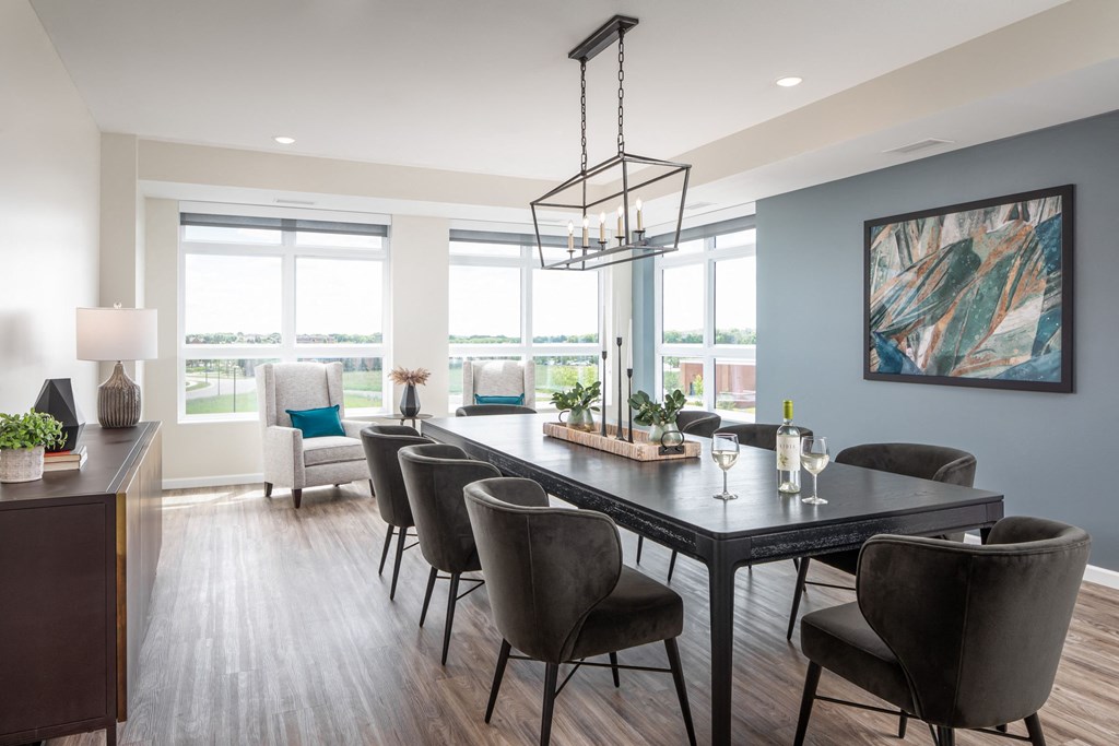 a dining room with a table and chairs and a large window