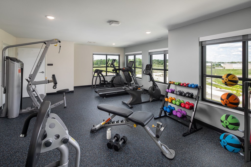 a gym with weights and other exercise equipment and windows