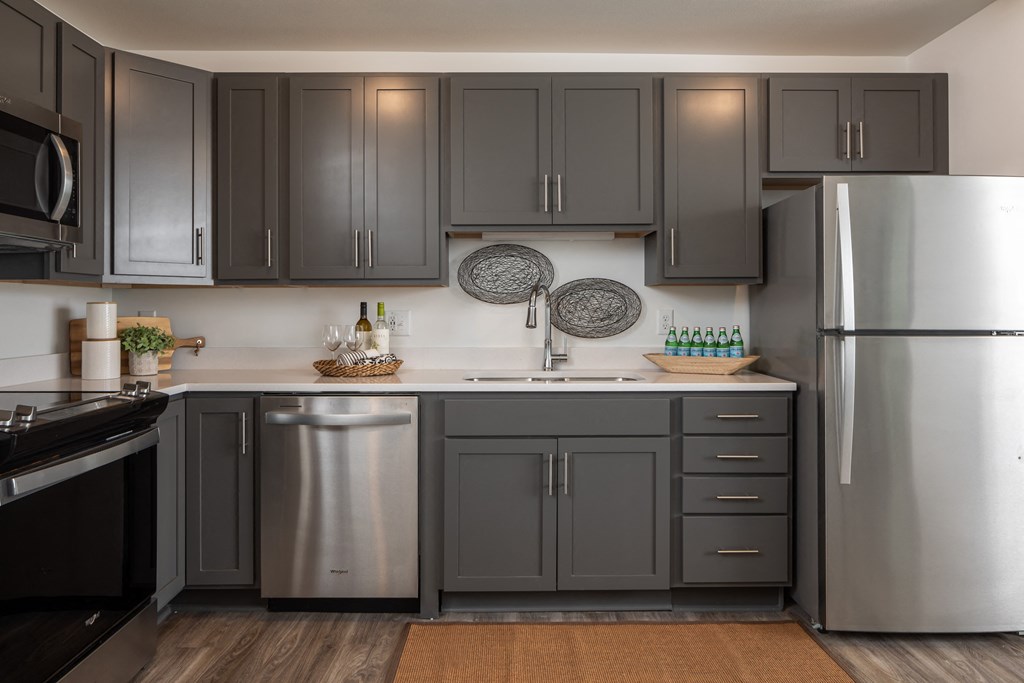 a kitchen with stainless steel appliances and gray cabinets