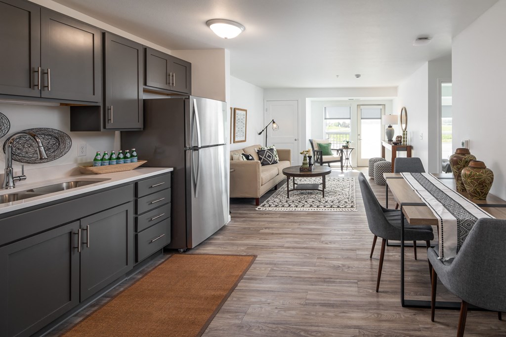 a kitchen and living room with a table and chairs and a refrigerator