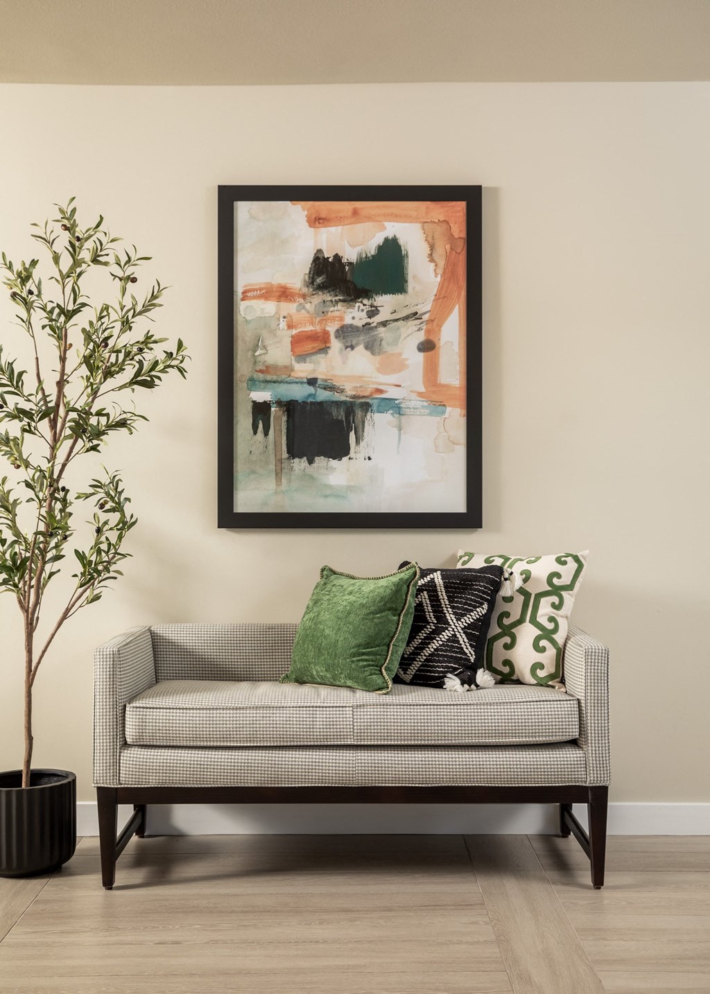 a couch with colorful pillows and a painting on the wall