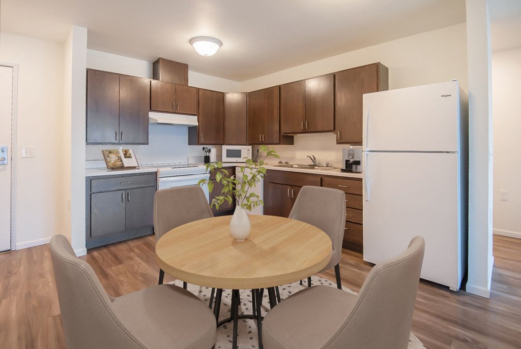 a kitchen and dining area with a table and chairs and a refrigerator