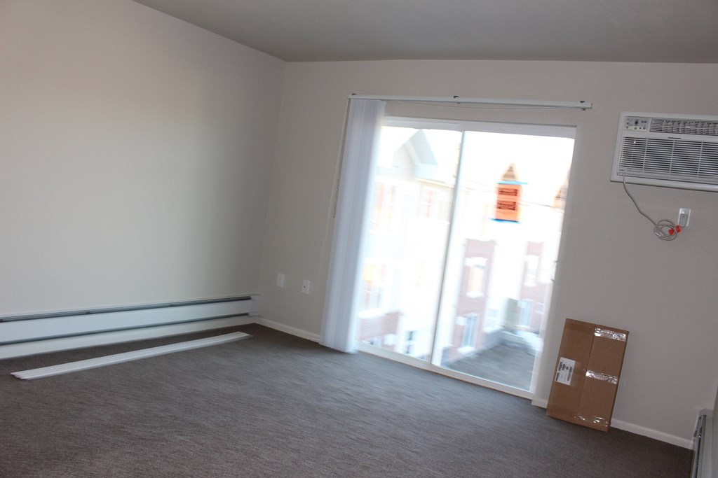 A room with a sliding glass door leading to a balcony.