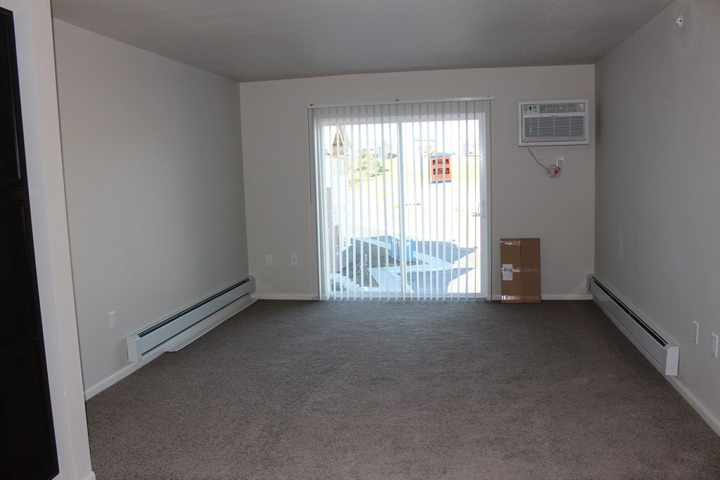 A room with a window and a car outside.