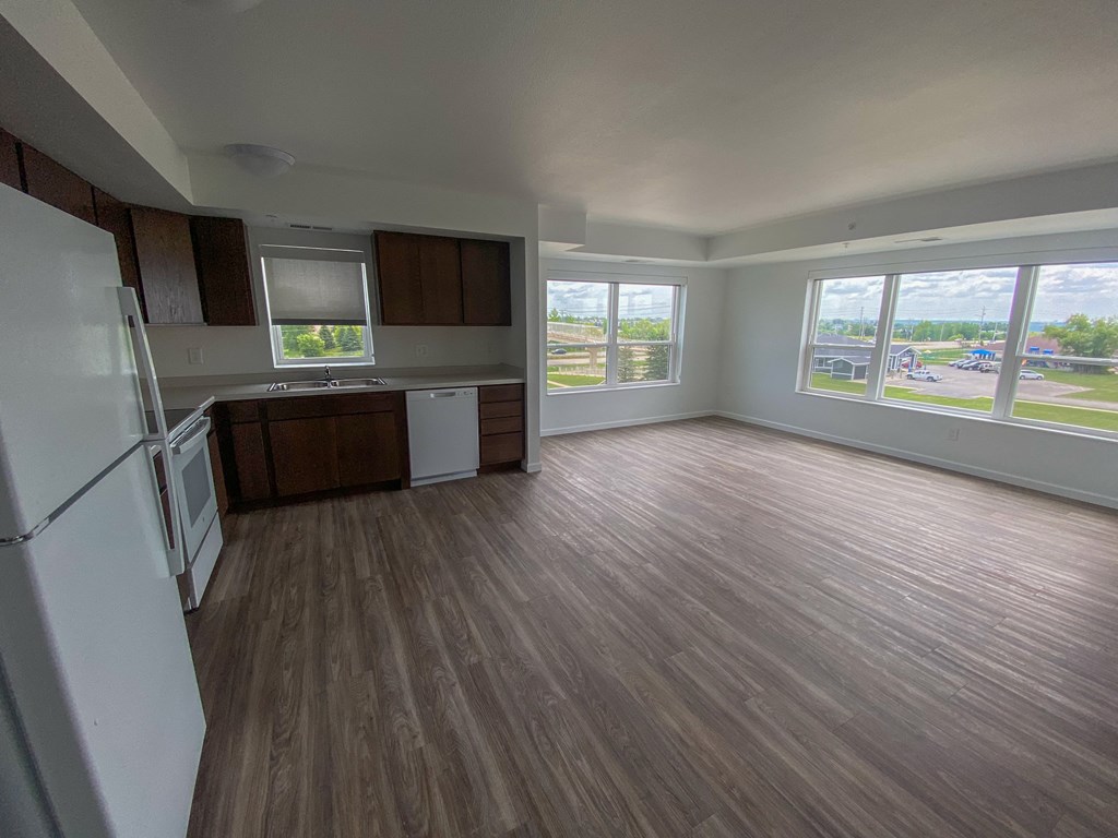 A kitchen with a white refrigerator and wooden floors.