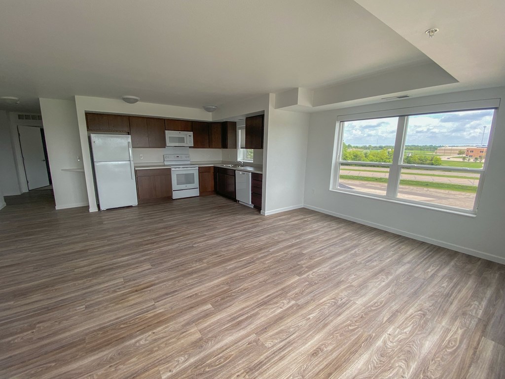 A kitchen with a refrigerator, microwave, and oven.