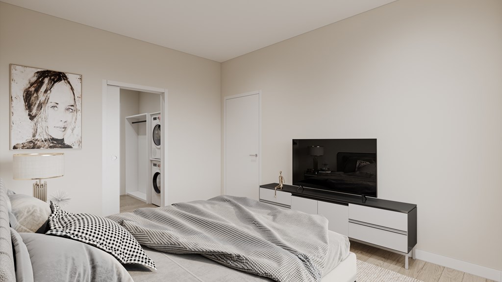 A bedroom with a bed, a television, and a painting on the wall.