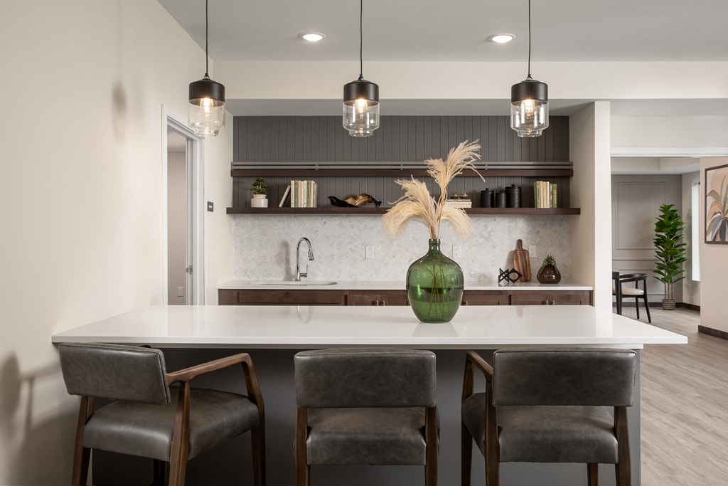 a kitchen with a marble counter top and chairs