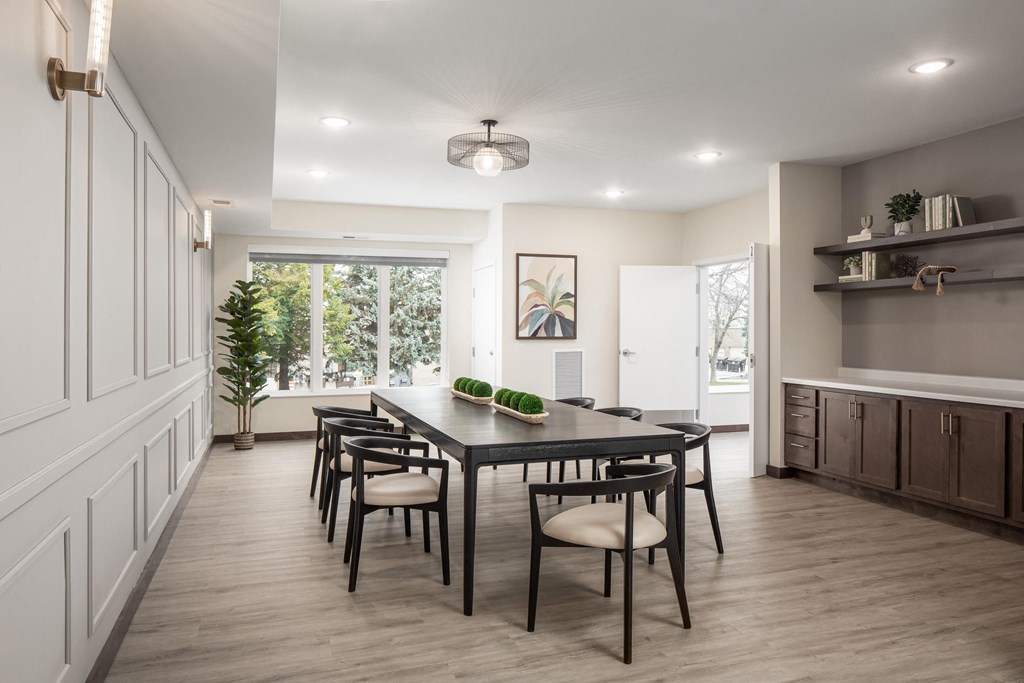 a dining room with a table and chairs and a large window
