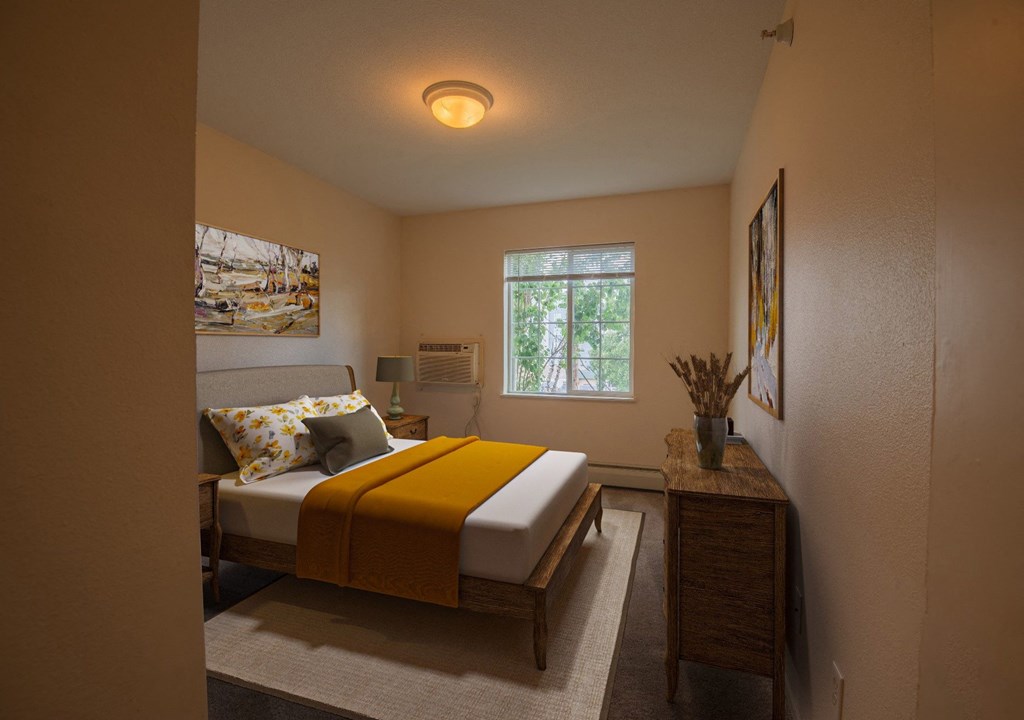 a bedroom with a bed with a yellow blanket on it