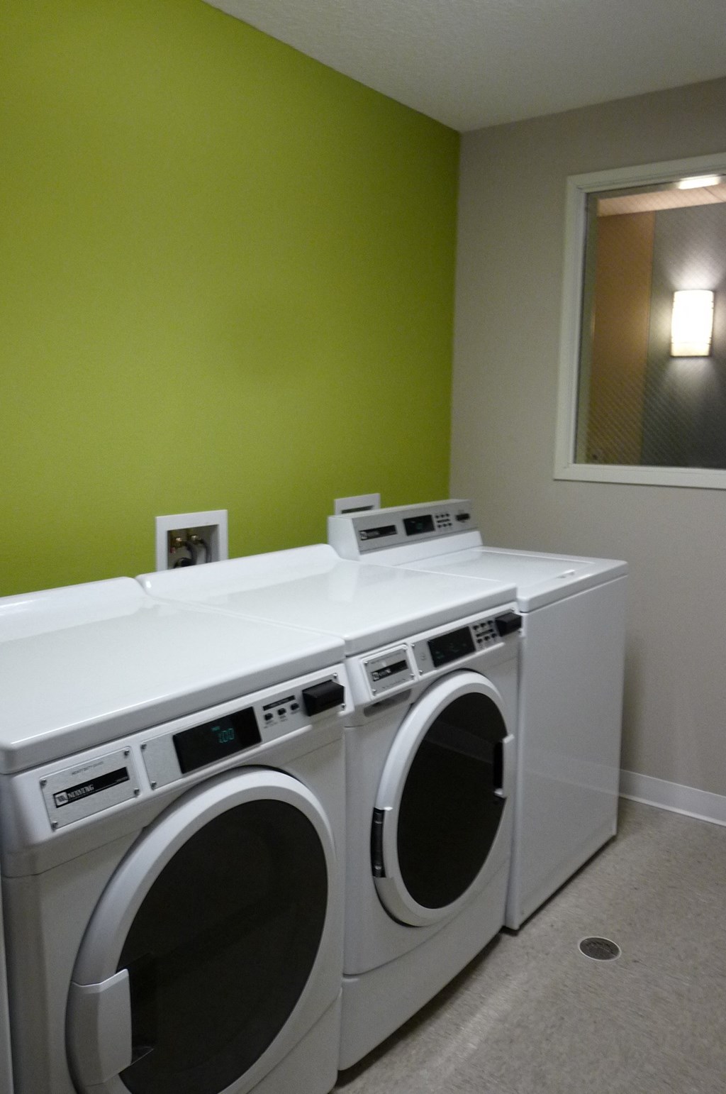 a washer and dryer in a laundry room with green walls