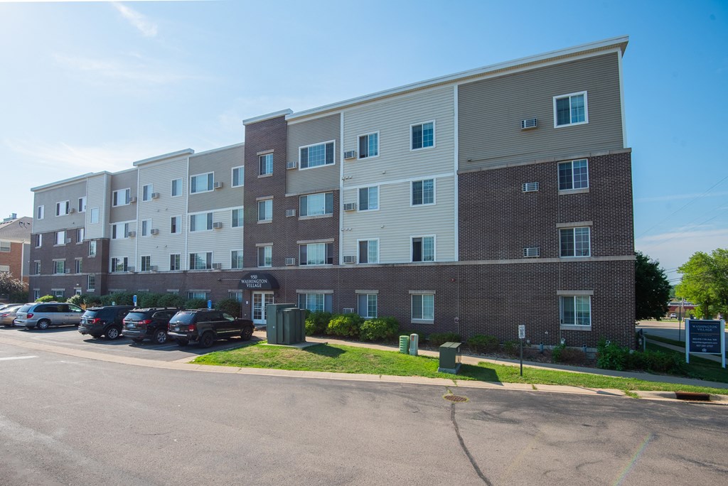 an apartment building with cars parked in front of it