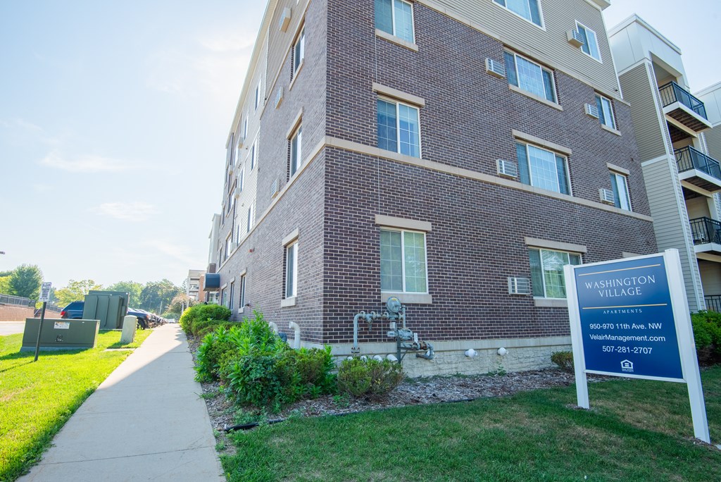 a brick apartment building with a sign in front of it
