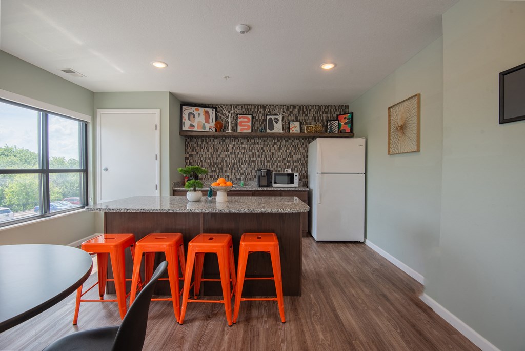 a kitchen with orange stools in front of a counter top